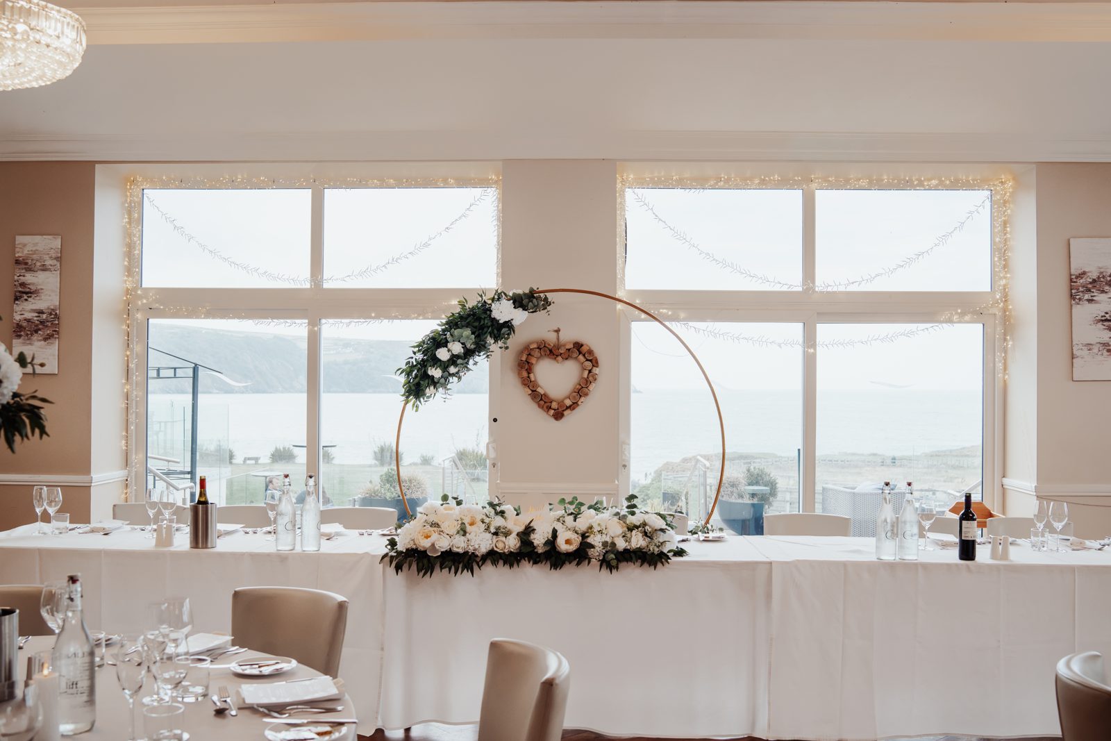 Top table with gold hoop arch and sea view